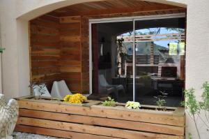 a wooden garden wall with a window and flowers at Gite Manzafaro in Sisteron +4 photos