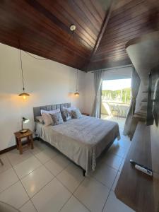 a bedroom with a large bed with a wooden ceiling at Apartamento Centro Búzios Luxo in Búzios