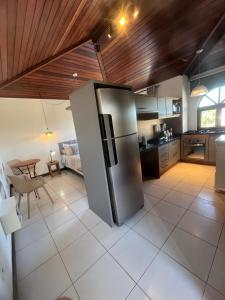 a kitchen with a stainless steel refrigerator in a room at Apartamento Centro Búzios Luxo in Búzios