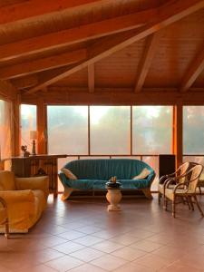 a living room with a green couch and chairs at La Favola Verde in Roccadaspide
