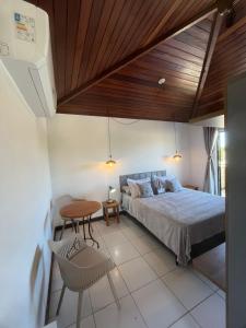 a bedroom with a bed and a wooden ceiling at Apartamento Centro Búzios Luxo in Búzios