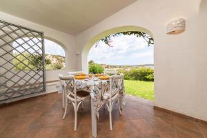 a dining room with a table and chairs and a window at NG Collection gli Oleandri in Liscia di Vacca