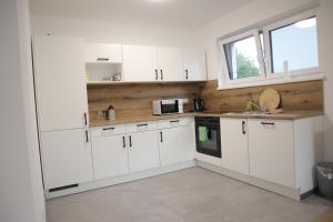 a white kitchen with white cabinets and a sink at Ferienhaus von Werner in Schlatt +13 photos