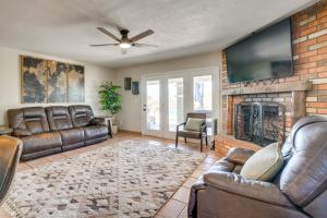 Il comprend un salon doté d'un mobilier en cuir et d'un mur en briques. dans l'établissement Backyard Oasis and Hot Tub Mtn-View Wickenburg Home, à Wickenburg