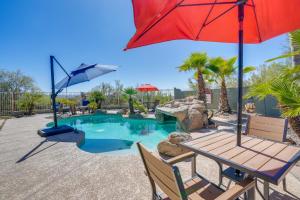 une piscine avec une table de pique-nique et un parasol dans l'établissement Backyard Oasis and Hot Tub Mtn-View Wickenburg Home, à Wickenburg