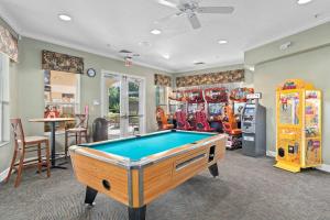 a pool table in a room with arcade games at Mickey's Hideaway Windsor Hills Resort in Orlando