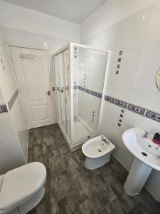 a bathroom with a toilet and a sink and a shower at Large Burnley Townhouse in Burnley