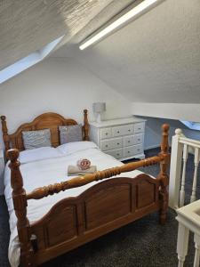 a bedroom with a wooden bed and a dresser at Large Burnley Townhouse in Burnley +21 photos
