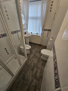 a bathroom with two toilets and a walk in shower at Large Burnley Townhouse in Burnley