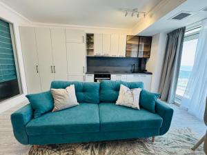 a blue couch in a living room with a kitchen at White Titanic -Luxury Turism in Mamaia Sat/Năvodari