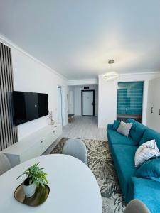 a living room with a blue couch and a table at White Titanic -Luxury Turism in Mamaia Sat/Năvodari