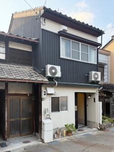 a house with two air conditioners on the side of it at 山二 -Yamafu in Imizu