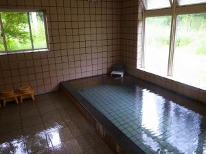 a bath tub in a room with a window at Minshuku Takizawa in Takayama