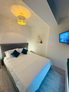 a bedroom with a white bed with a tv on the wall at White Titanic -Luxury Turism in Mamaia Sat/Năvodari