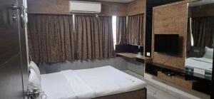 a small room with a bed and a mirror at Calangute Square by Ananta in Calangute