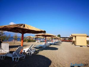 a row of chairs and umbrellas on a beach at Studio apartman Kata Nin in Nin