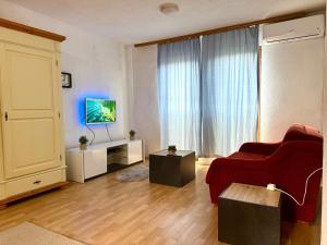 a living room with a red couch and a tv at New Hill house in Visoko