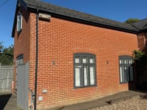 a red brick building with two windows on it at 2 Guests - Studio - Ideal for Goodwood & Beach in Pagham