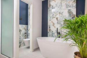 a bathroom with a white tub and a toilet at Samstag ParkZone in Split