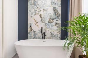 a bath tub in a bathroom with a wall at Samstag ParkZone in Split