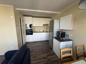 a small kitchen with white cabinets and a blue couch at Apartament Bazyliańska, metro Bródno in Warsaw +9 photos