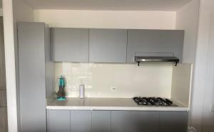 a kitchen with white cabinets and a stove top oven at Conjunto Peñazul La Aldea in Ricaurte