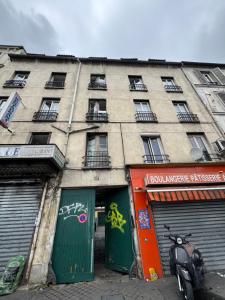 a building with two green doors and a scooter parked in front at Hostel Wilson in Saint-Denis