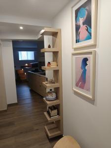 a living room with two pictures on the wall and a shelf at El Apartamento de Hervás in Hervás