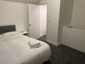a bedroom with a white bed with two towels on it at Modern Five Bed Long Stays and Contractors Welcome in Burnley