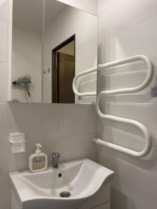a white bathroom with a sink and a mirror at Quiet Comfortable Stay - Energetiku g 32, Visaginas in Visaginas +40 photos