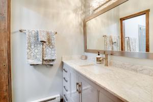 a bathroom with a sink and a mirror at Charming Townhome - Walk to Greek Peak Mountain! in Cortland