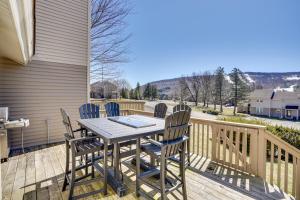a wooden deck with a table and chairs on it at Charming Townhome - Walk to Greek Peak Mountain! in Cortland