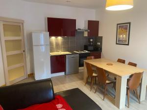 a kitchen and dining room with a table and a refrigerator at Val-locations la paix 7 in Le Mont-Dore