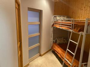 a room with two bunk beds and a door at Val-locations la paix 7 in Le Mont-Dore