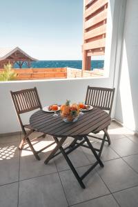 Una mesa con un bol de fruta en un balcón. en KAP Alizés RDC appartement face à l'océan, en Saint-Pierre