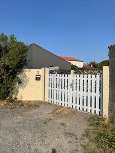 a white fence in front of a house at Maison individuelle Aytré plage terrain clos 280m2 très calme in Aytré