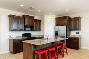 a kitchen with wooden cabinets and red bar stools at Ridge House - Two Pools Near Zion in Washington