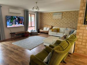 Una sala de estar con un perro acostado en un sofá. en Sandy Paws and Salty Air, en Lancelin