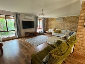 Una sala de estar con un sofá y un televisor en Sandy Paws and Salty Air, en Lancelin 8 fotos más