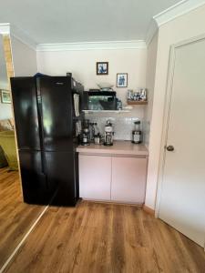 cocina con nevera negra en una habitación en Sandy Paws and Salty Air, en Lancelin