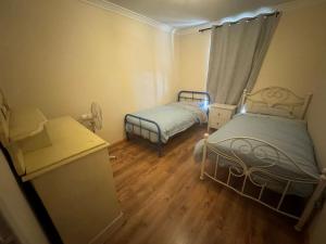 Un dormitorio pequeño con dos camas y una ventana. en Sandy Paws and Salty Air, en Lancelin