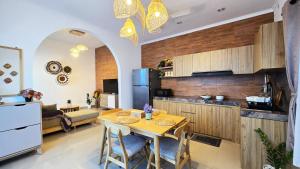 eine Küche und ein Wohnzimmer mit einem Tisch und einem Kühlschrank in der Unterkunft MauLagi Bali Getaway in Jimbaran