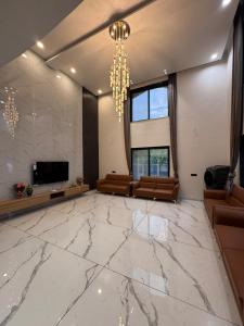 a large living room with a large marble floor at Bhargavi Villa in Kolvan