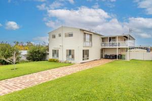 ein großes weißes Haus mit einem großen Garten in der Unterkunft Saltwater Sanctuary, by the sea in Ledge Point