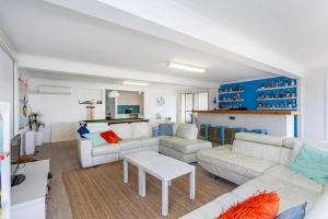 ein Wohnzimmer mit weißen Möbeln und blauen Schränken in der Unterkunft Saltwater Sanctuary, by the sea in Ledge Point