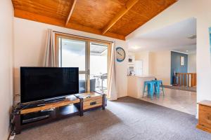 ein Wohnzimmer mit einem großen Flachbildfernseher in der Unterkunft Saltwater Sanctuary, by the sea in Ledge Point