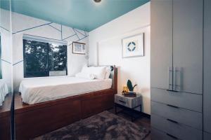 una piccola camera da letto con un letto e una finestra di Functional stay near airport, business districts a Manila Altre 27 foto