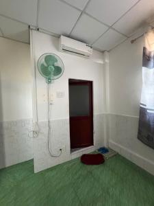 a room with a shower with a fan on the wall at Motel Hoàn Chun in Can Tho