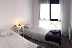 due letti in una stanza con finestra di La Casita de las Vistas a Los Ángeles de San Rafael