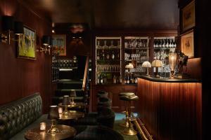 a bar with stools and a shelf with alcohol at Milestone Hotel Kensington in London +215 photos